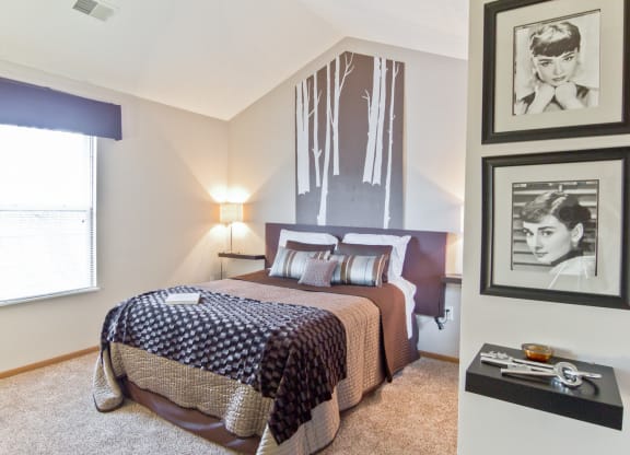 a bedroom with a bed and pictures on the wall