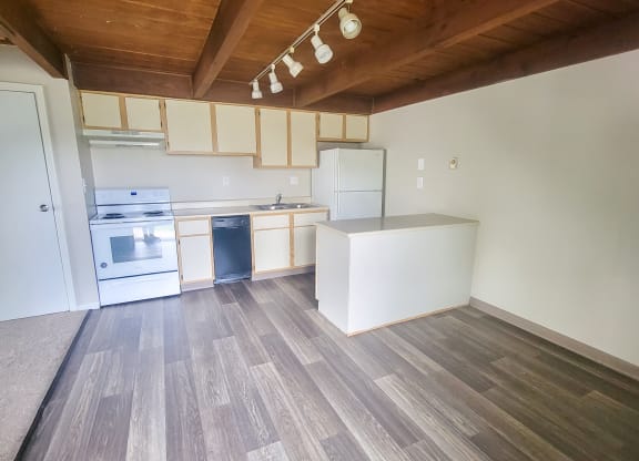 a kitchen with white cabinets and a wooden ceiling