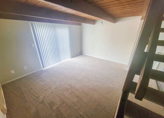 an empty attic with a ladder leading up to a loft