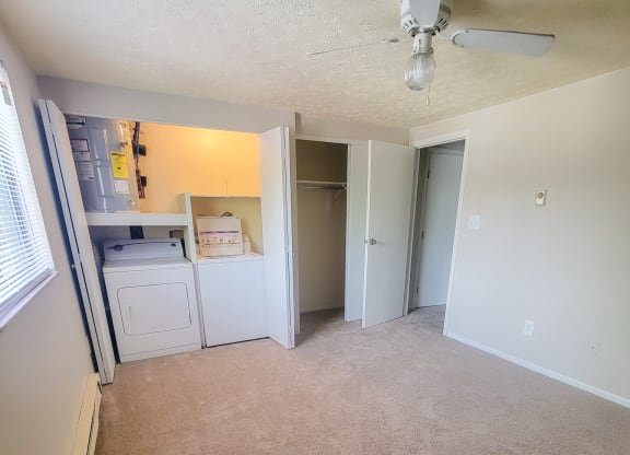 an empty living room with a ceiling fan