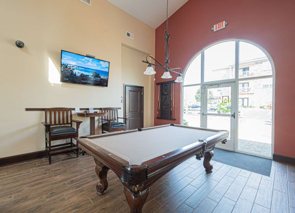 a games room with a pool table and a tv