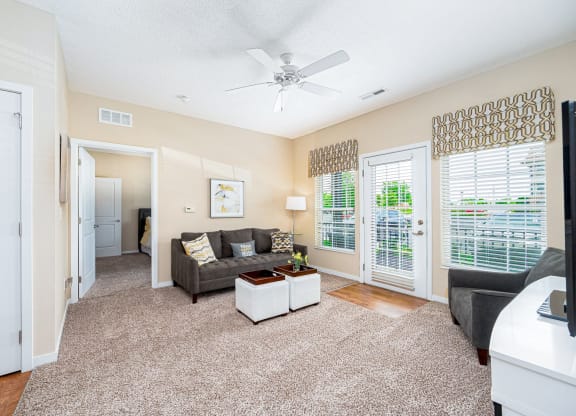 a living room with a couch and a ceiling fan