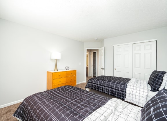 a bedroom with two beds and a closet