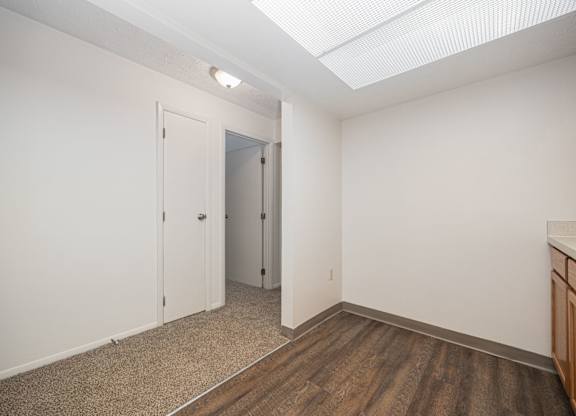 A room with a white door and a brown floor.