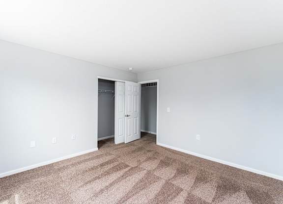 A room with a carpeted floor and a white door.