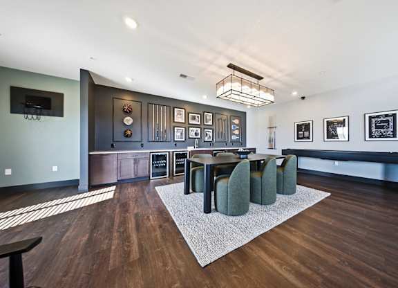 A modern dining room with a dark wood table and green chairs.