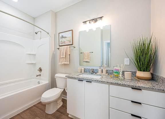 A white bathroom with a toilet, sink, and bathtub.