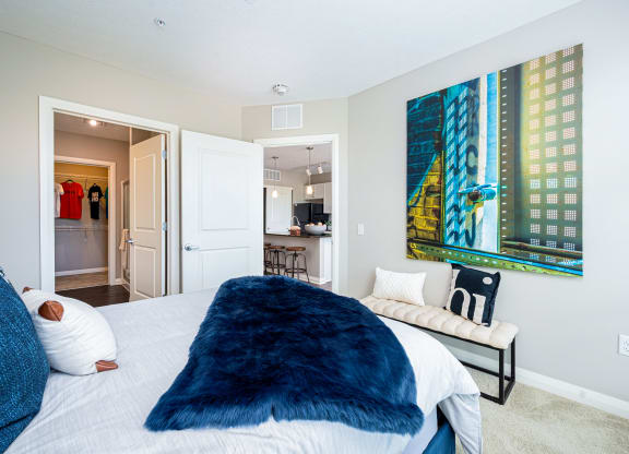 a bedroom with a large bed and a painting on the wall