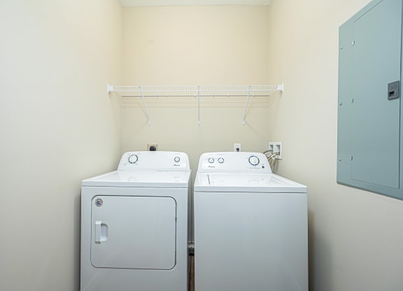 a washer and dryer in a room with a white wall and a closet