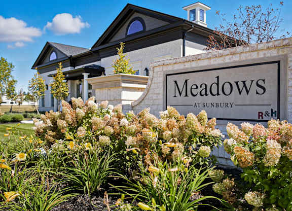 A sign that says Meadows at Sunbury in front of a building.