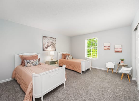 a bedroom with two beds and a window