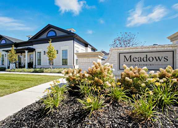 A sign that says Meadows in front of a house.