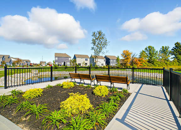 A park with a bench and a fence.