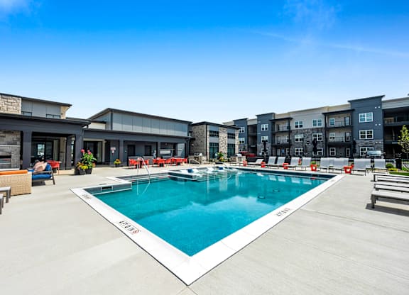 A large outdoor swimming pool with a white edge and a white metal railing.