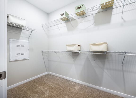 a spacious closet with shelves and a dryer in the corner of the room