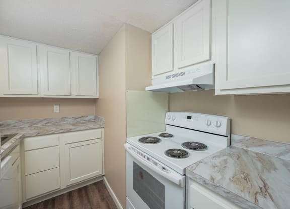 a kitchen with white appliances and marble counter tops