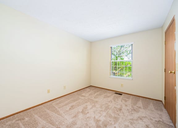 a room with carpet and a door and a window