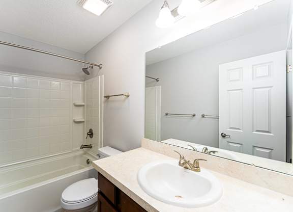 A white bathroom with a sink, toilet, and bathtub.