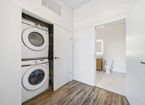 A laundry room with a washer and dryer stacked on top of each other.