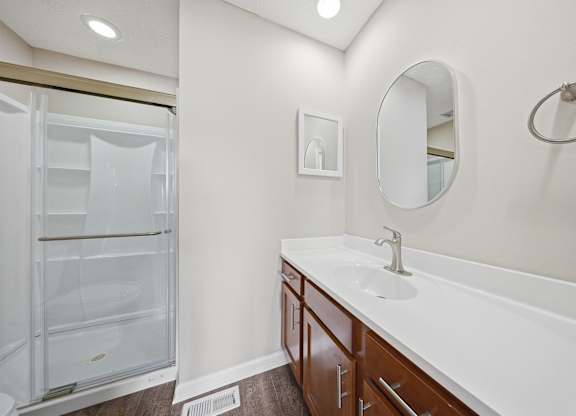 A bathroom with a white sink and a white fridge.