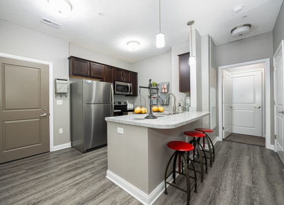 a kitchen with stainless steel appliances and a bar with stools
