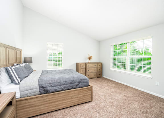 a bedroom with a bed and two windows