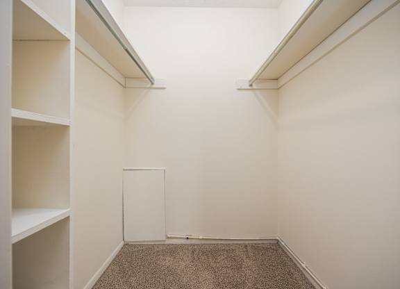 A white room with a carpeted floor and white walls.