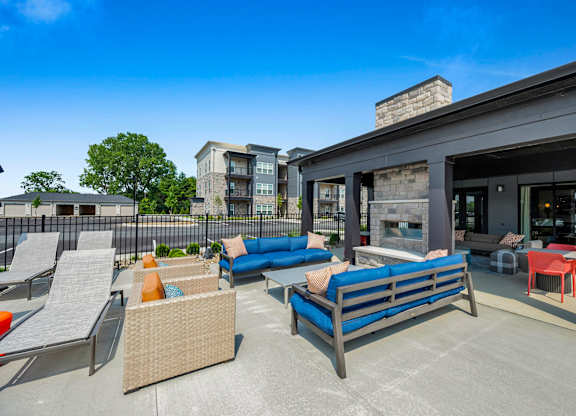 A patio with a blue couch and chairs.