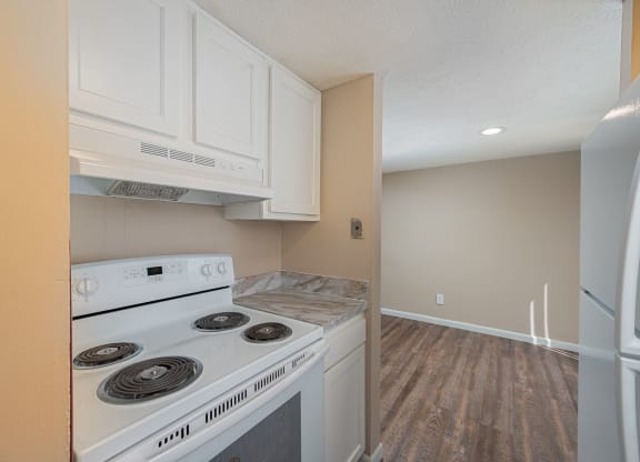 a kitchen with white cabinets and a stove and a refrigerator