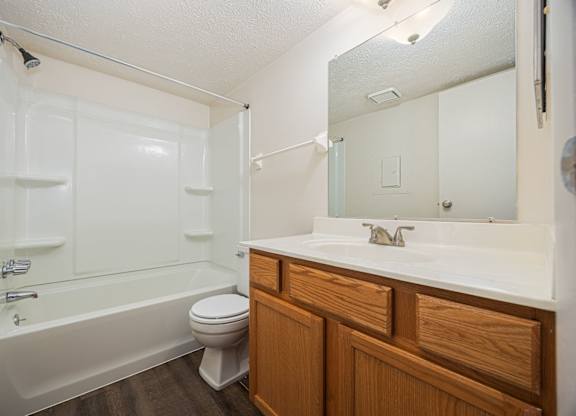 A white bathroom with a toilet, sink, and bathtub.