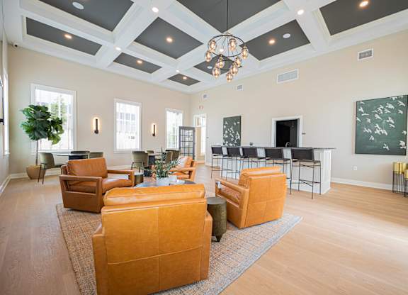 A living room with a large orange sofa and a chandelier hanging from the ceiling.