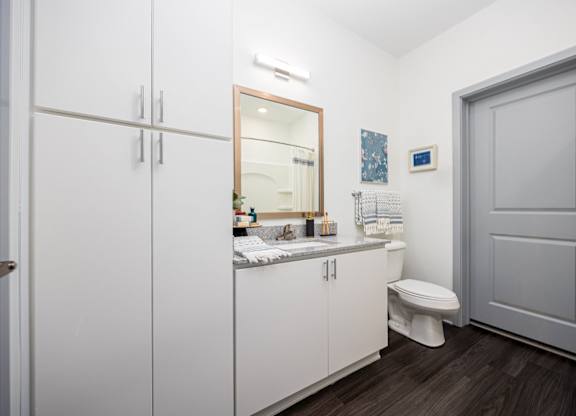 A bathroom with a toilet, sink, and medicine cabinet.