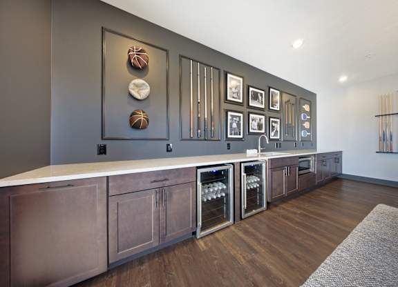 A kitchen with a long counter and a row of wine glasses on the wall.