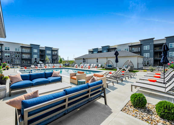 A sunny day at a poolside with blue seating and a statue.