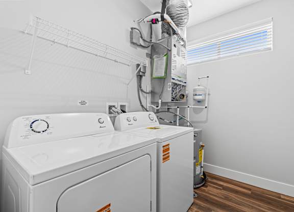 A white washing machine and dryer in a small laundry room.