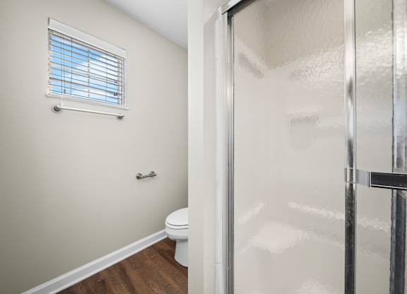 A bathroom with a toilet and a shower.