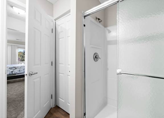 A white bathroom with a glass shower door.