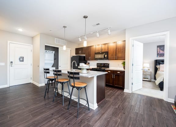 a kitchen with a bar and stools in a living room