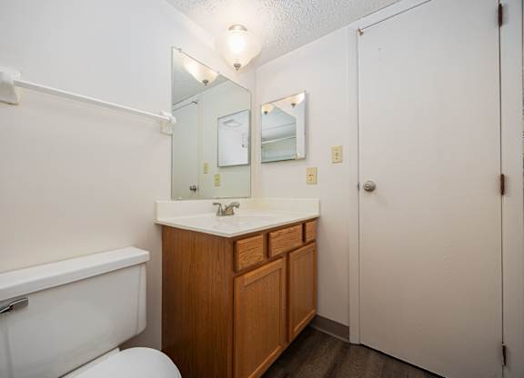 A white toilet sits next to a sink in a small bathroom.