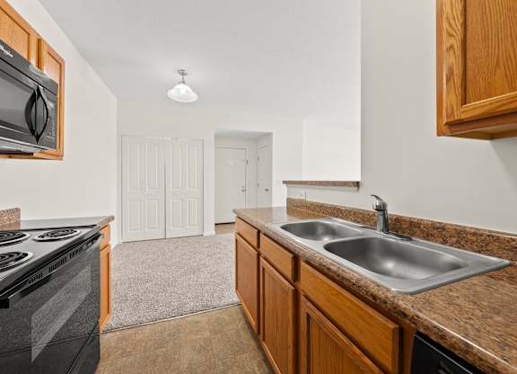 A kitchen with brown cabinets and a black stove top oven.