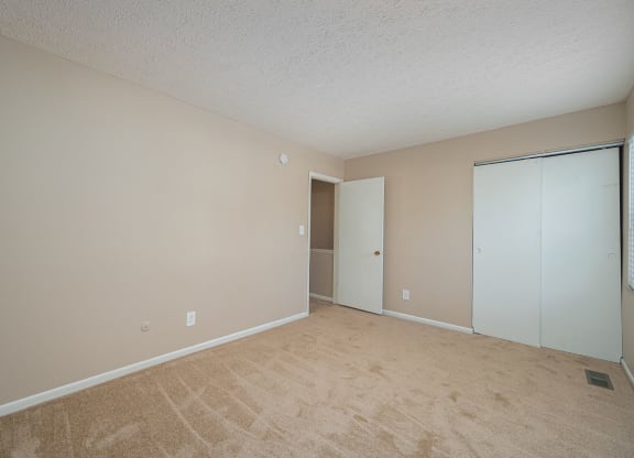 an empty living room with a door to a closet