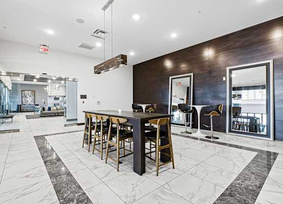 A modern kitchen with a bar area and a dining table.
