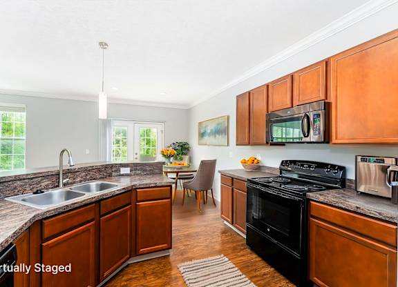 A kitchen with wooden cabinets and a black stove top oven.