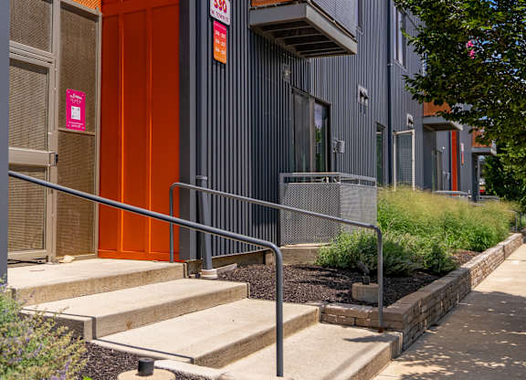 A building with a red door and a metal railing.