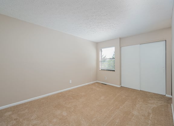 an empty living room with white walls and a window