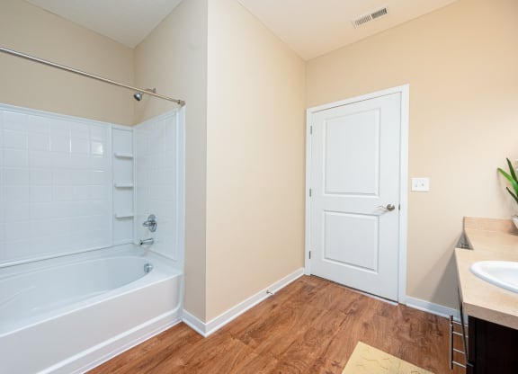 a bathroom with a tub and a shower and a sink
