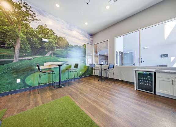 A room with a large mural of a golf course on the wall.