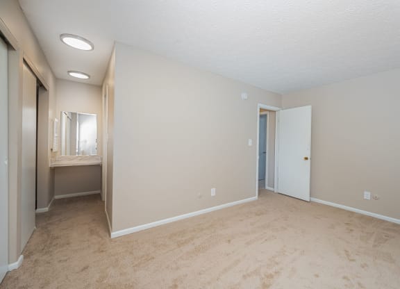 an empty living room with a bathroom and a closet