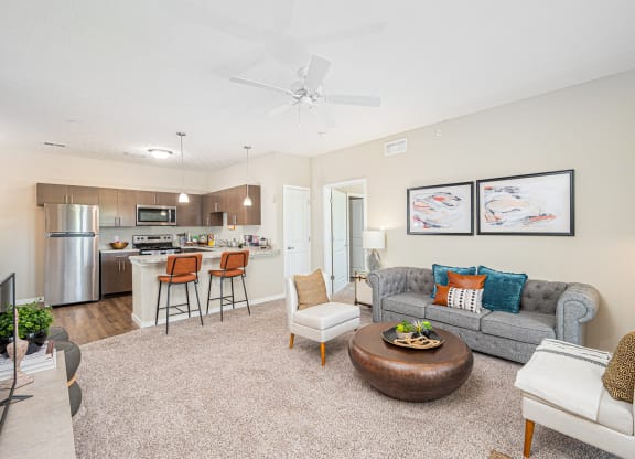a living room with a couch and a chair and a kitchen