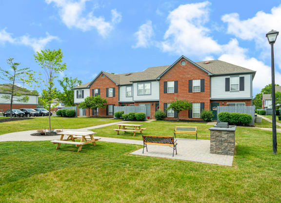 a park with picnic tables in front of a house
